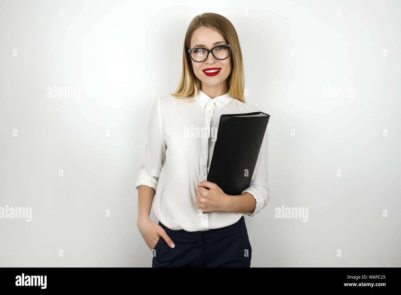 young beautiful business woman in eyeglasses holding black folder with ...