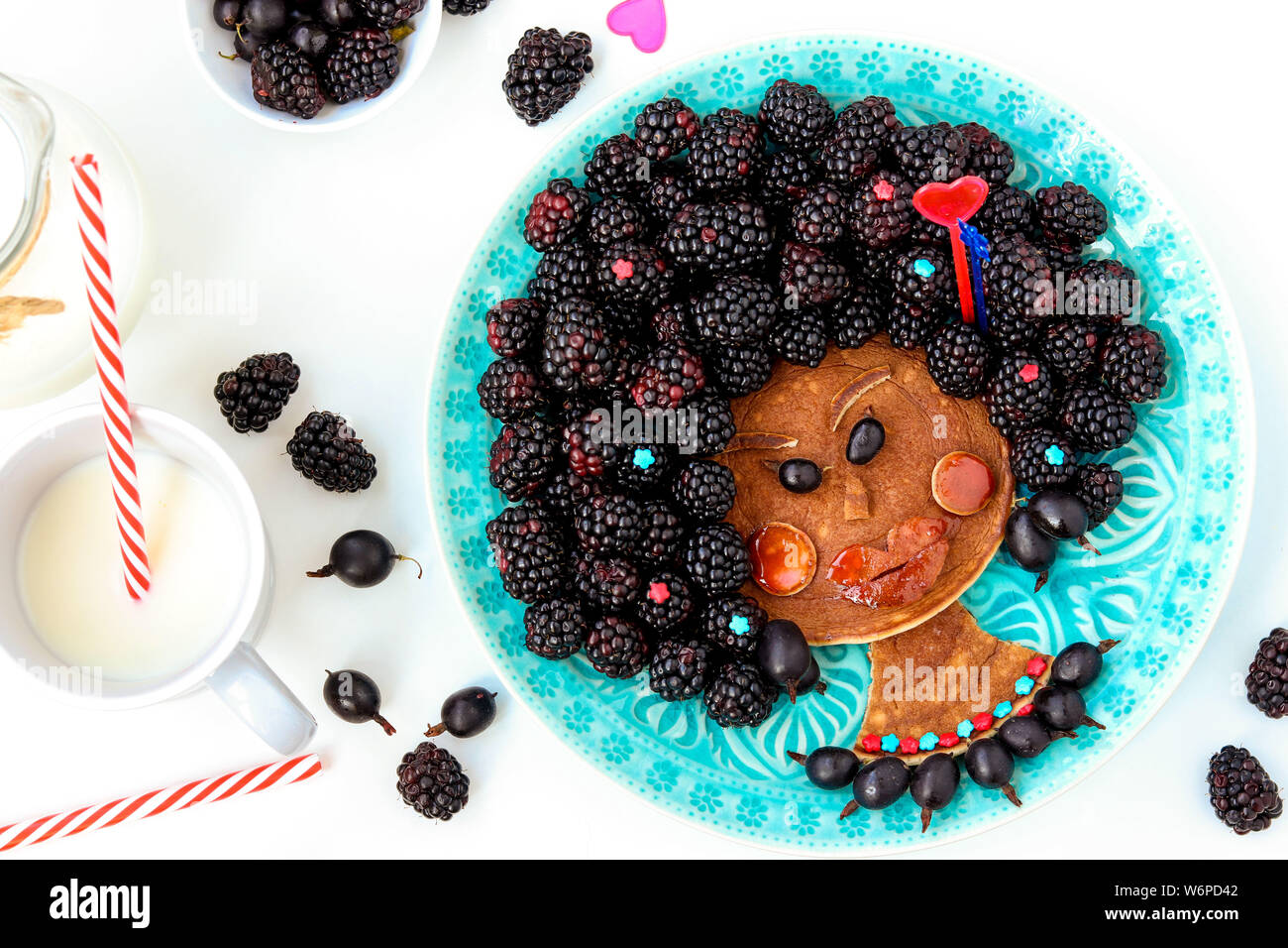Funny food idea for children edible negro girl, face from pancake, gooseberry and blackberry, food art Stock Photo