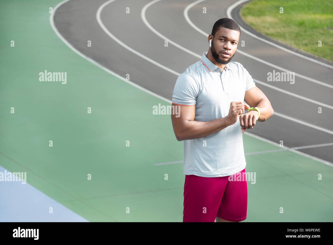 Serious fit young sportsman with a fitness tracker Stock Photo