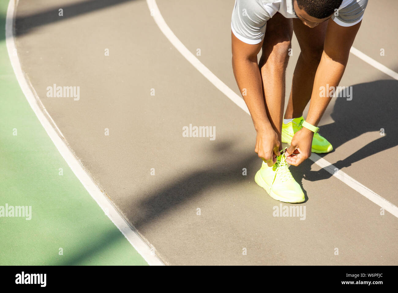 Young male athlete tying laces at the stadium Stock Photo