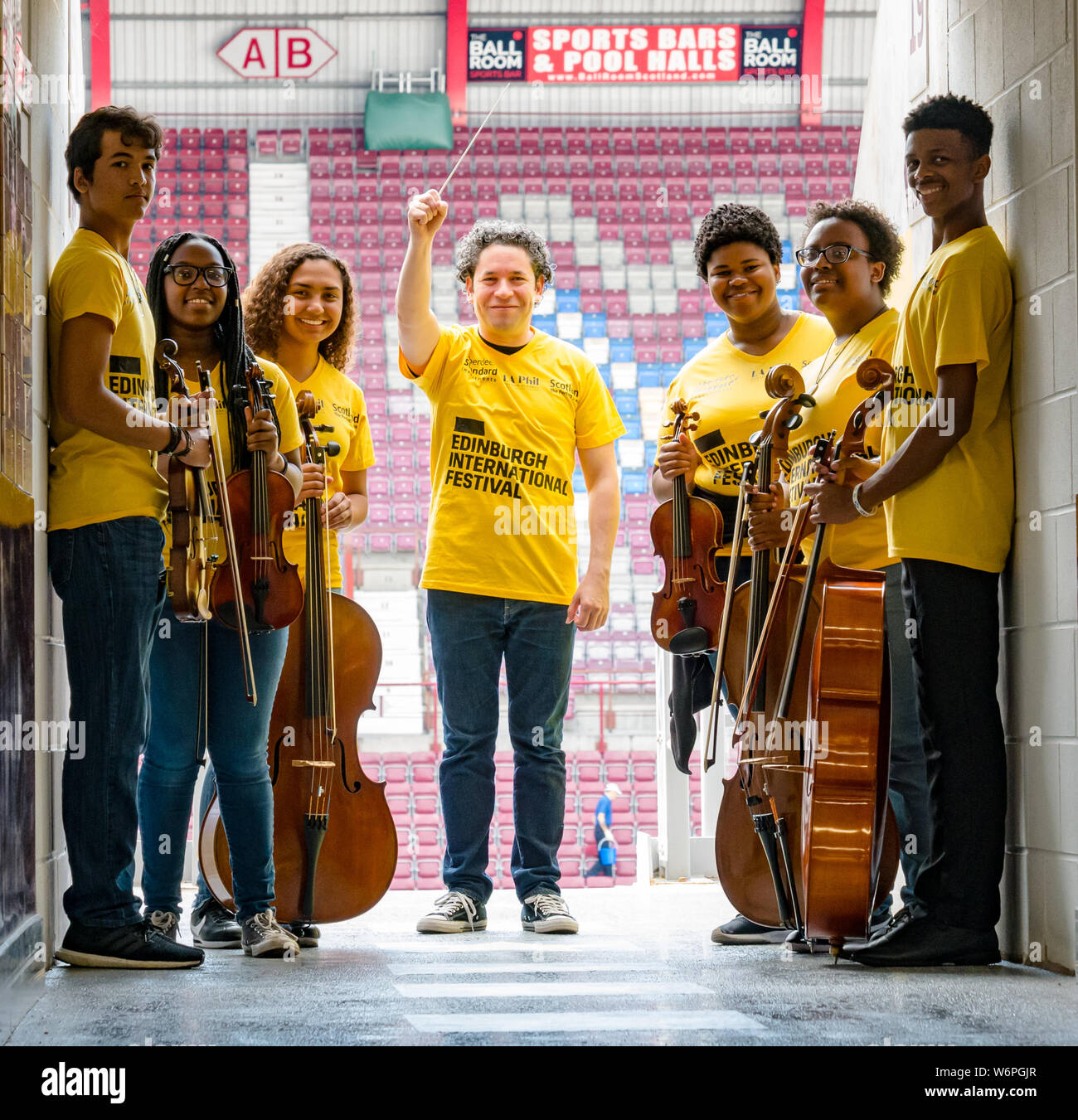 Edinburgh, Scotland, United Kingdom, 2 August 2019. Edinburgh Festival Fringe: Photocall prior to Edinburgh International Festival Aberdeen Standard Investments concert with LA Phil with conductor Gustavo Dudamel and members of the Youth Orchestra of Los Angeles. LA Phil at Tynecastle stadium, home to Hearts football club Stock Photo