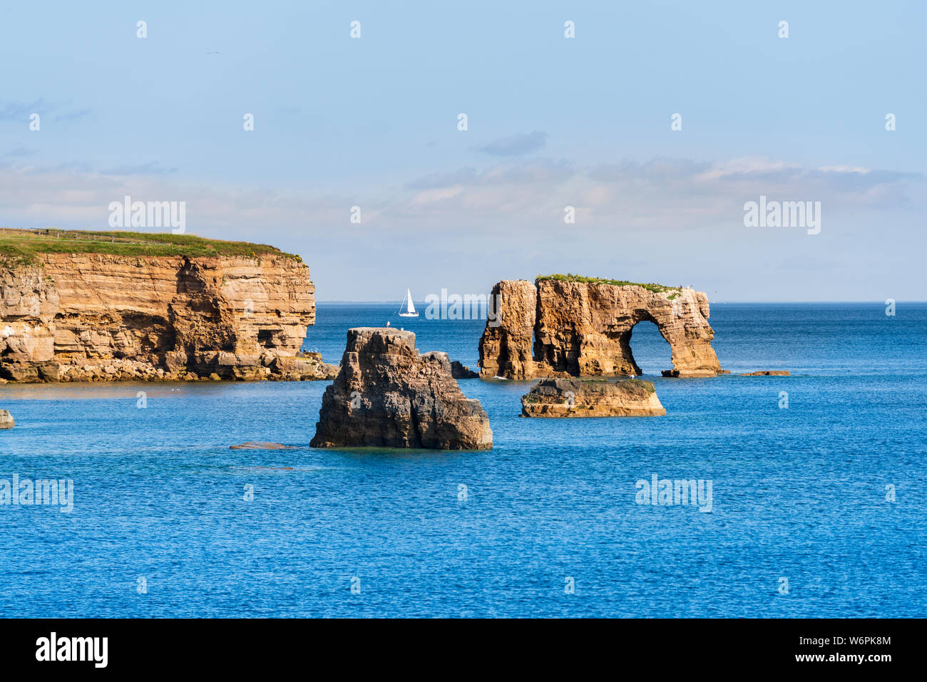The rocky cliffs leading to Lizard Point  and the rock arch sea-stack on the South Tyneside coast  at at Souter between Whitburn and Marsden Stock Photo