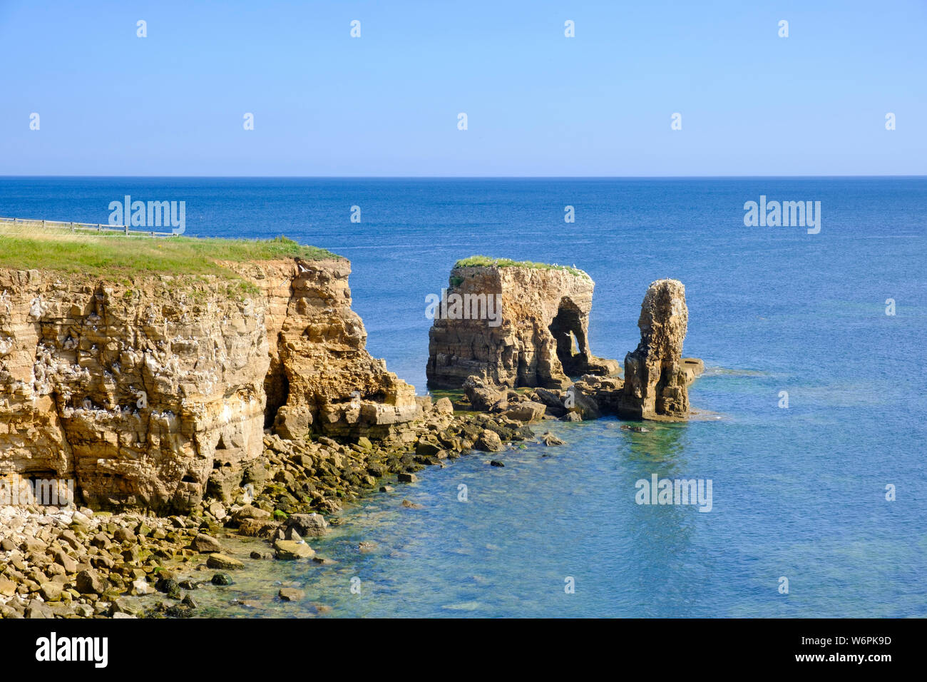 The rocky cliffs leading to Lizard Point  and the rock arch sea-stack on the South Tyneside coast  at at Souter between Whitburn and Marsden Stock Photo