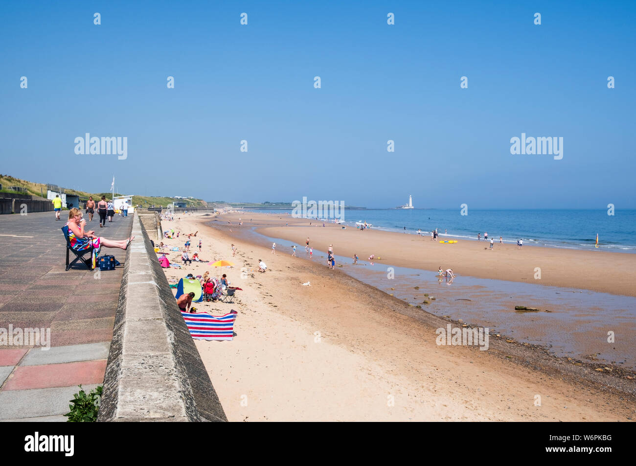 Summer at the seaside where families enjoy a sunny day on the long sandy beach on the North Tyneside coast at Whitley Bay in Tyne and Wear Stock Photo