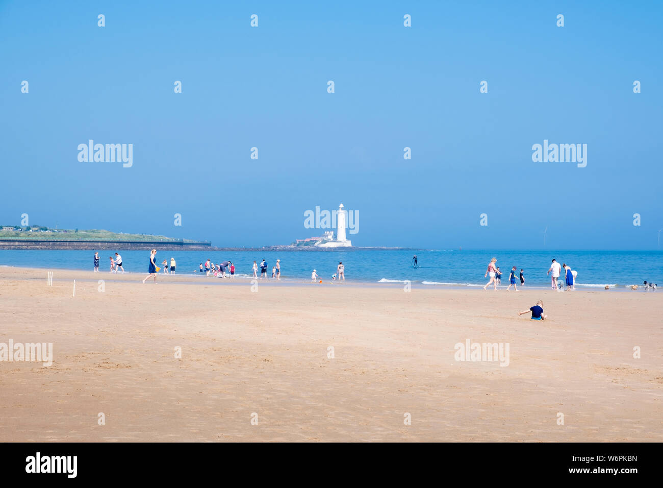 Summer at the seaside where families enjoy a sunny day on the long sandy beach on the North Tyneside coast at Whitley Bay in Tyne and Wear Stock Photo