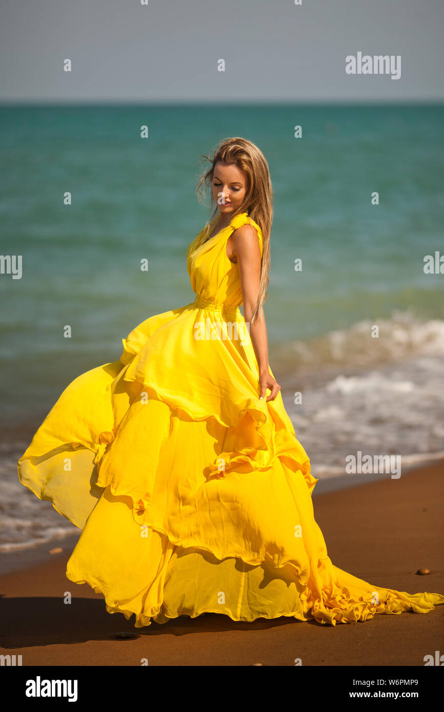 beautiful girl in a yellow dress by the sea Stock Photo Alamy