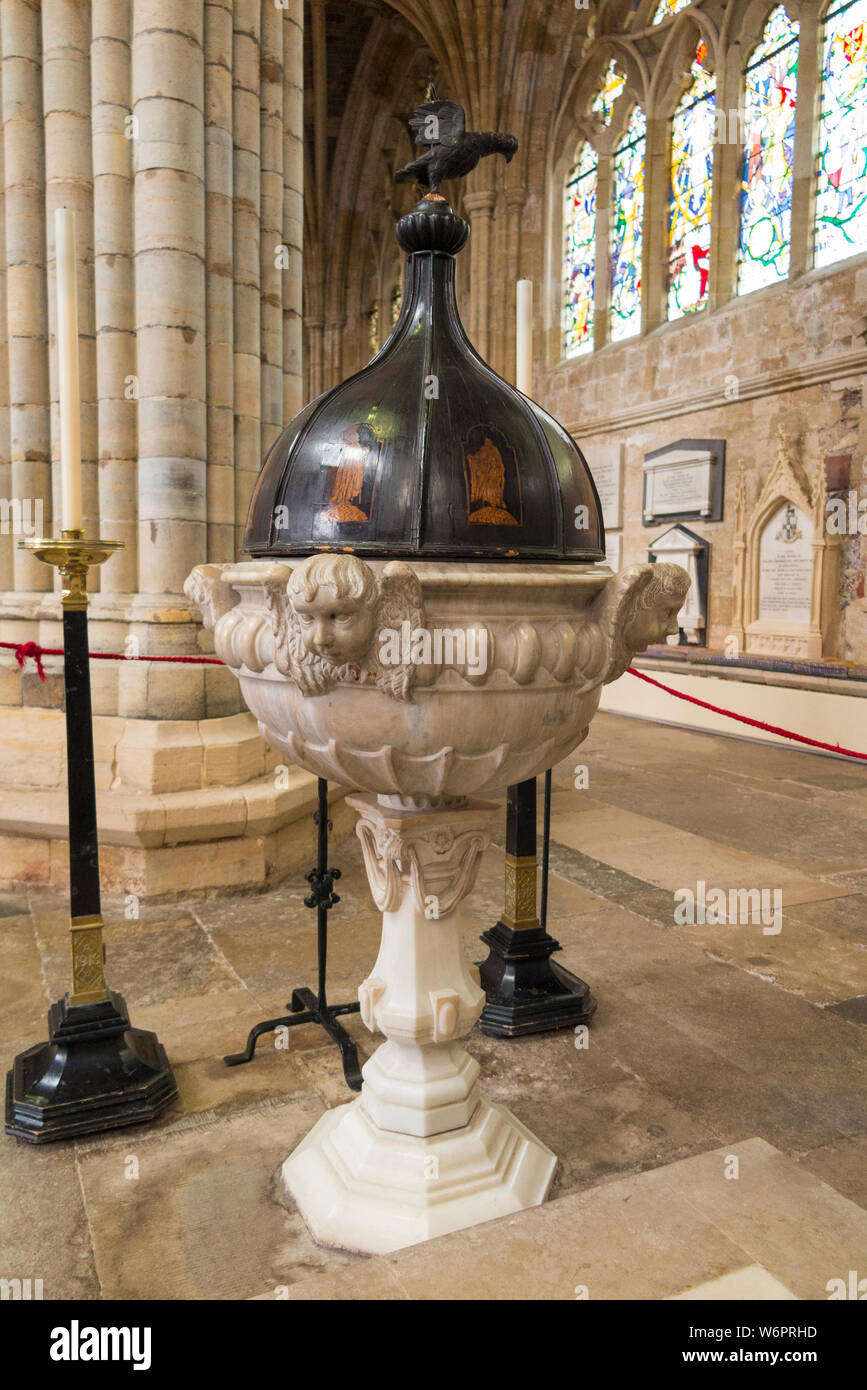 Baptismal font in the nave of Exeter Cathedral; in the Southwest corner of the nave is the baptismal font (1687) carved from Sicilian marble with an oak cover inlaid with eight figures of apostles. Exeter, UK. (110) Stock Photo