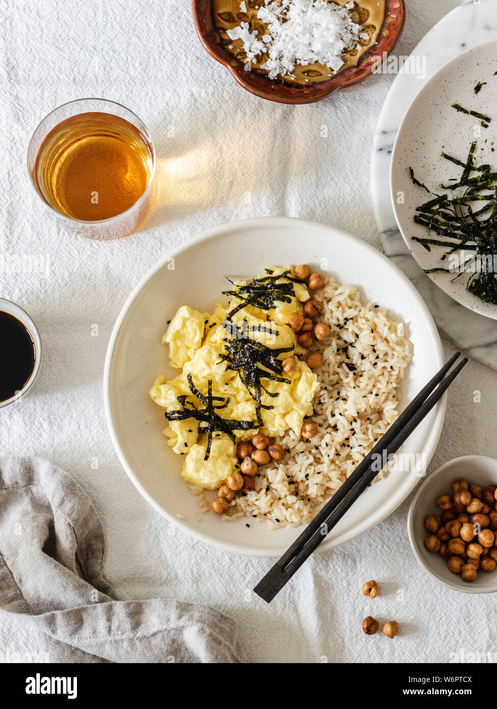 Japanese style scrambled eggs with rice chickpeas and nori served in white bowl with chopsticks Stock Photo
