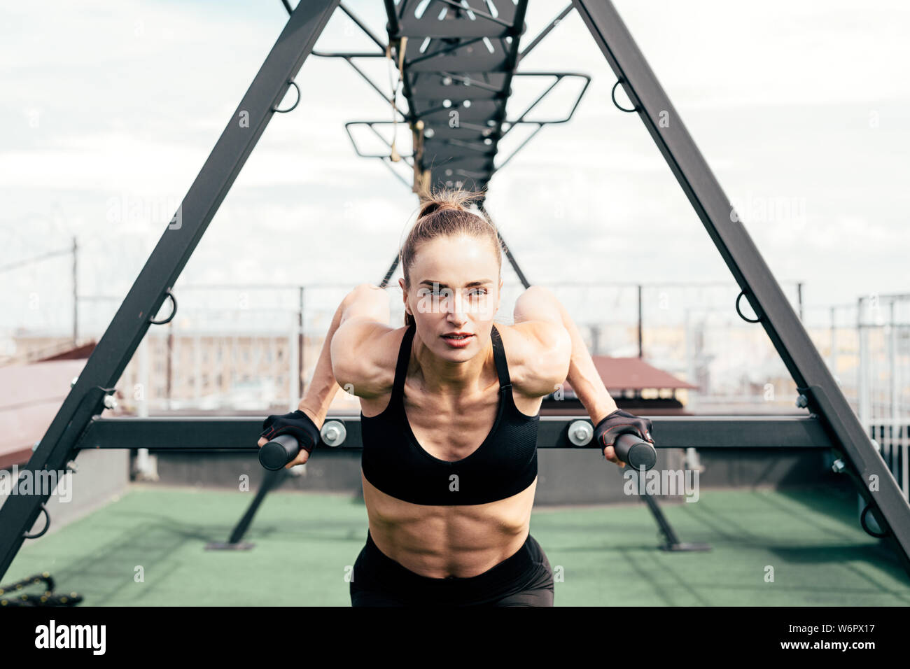 Fitness woman doing triceps dip using power rack on a terrace Stock Photo