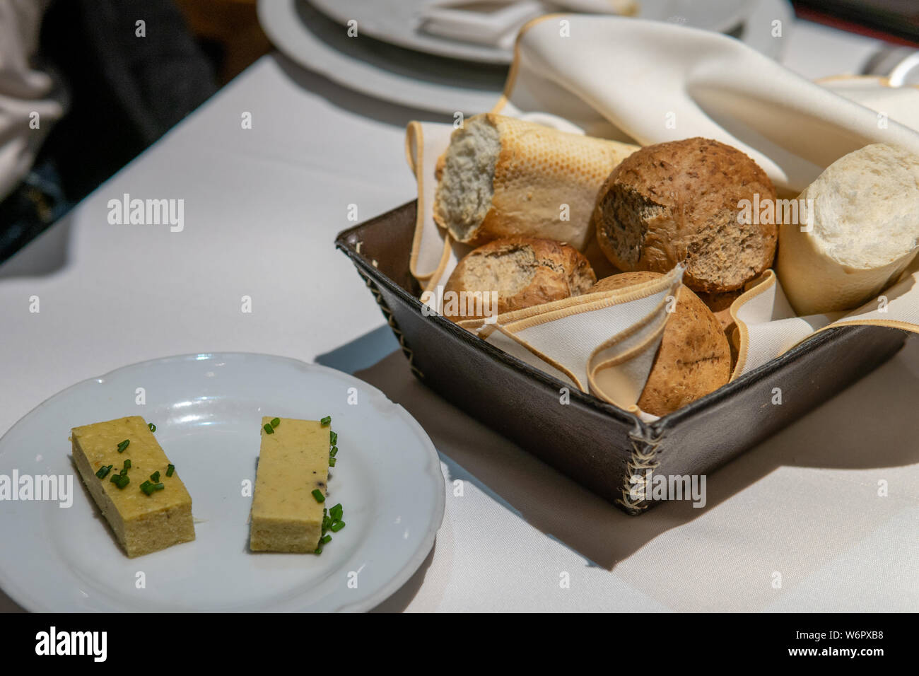 Bread Basket on Set Kitchen Table with butter Stock Photo