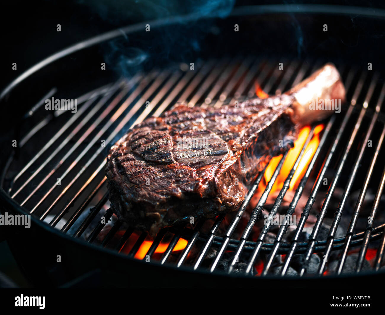 Angus beef tomahawk steak being grilled on a BBQ Stock Photo