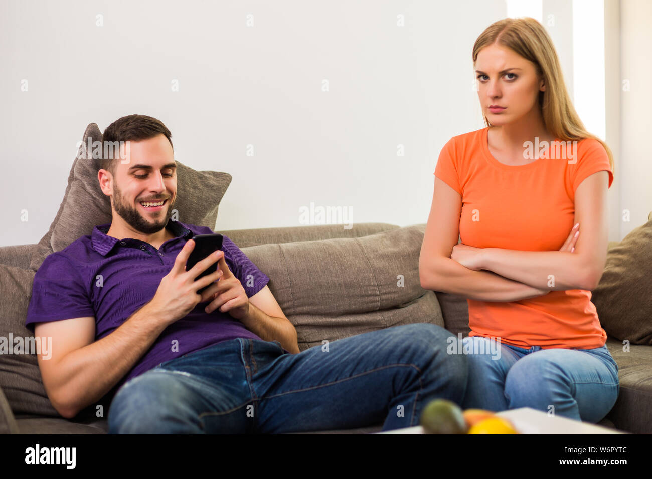 Angry wife and husband are having conflict because husband is using