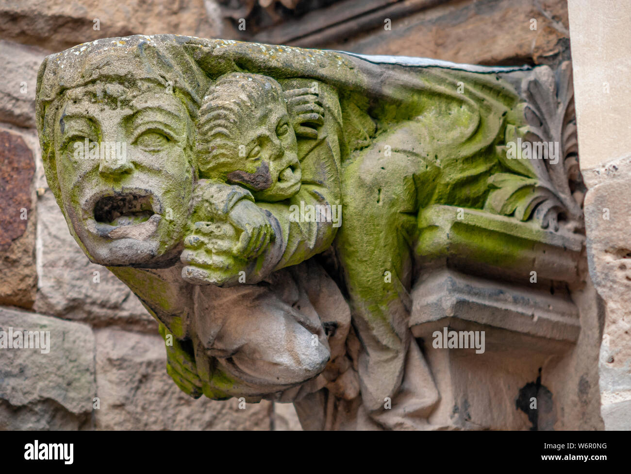 Architectural detail of St.Martin Church in Birmingham, England. It shows a man covering the mouth of a large face. Stock Photo