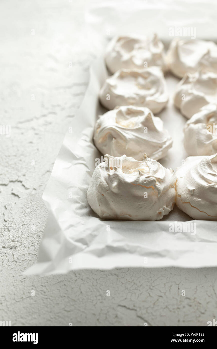 Meringues on baking parchment, on a white textured background Stock Photo Alamy