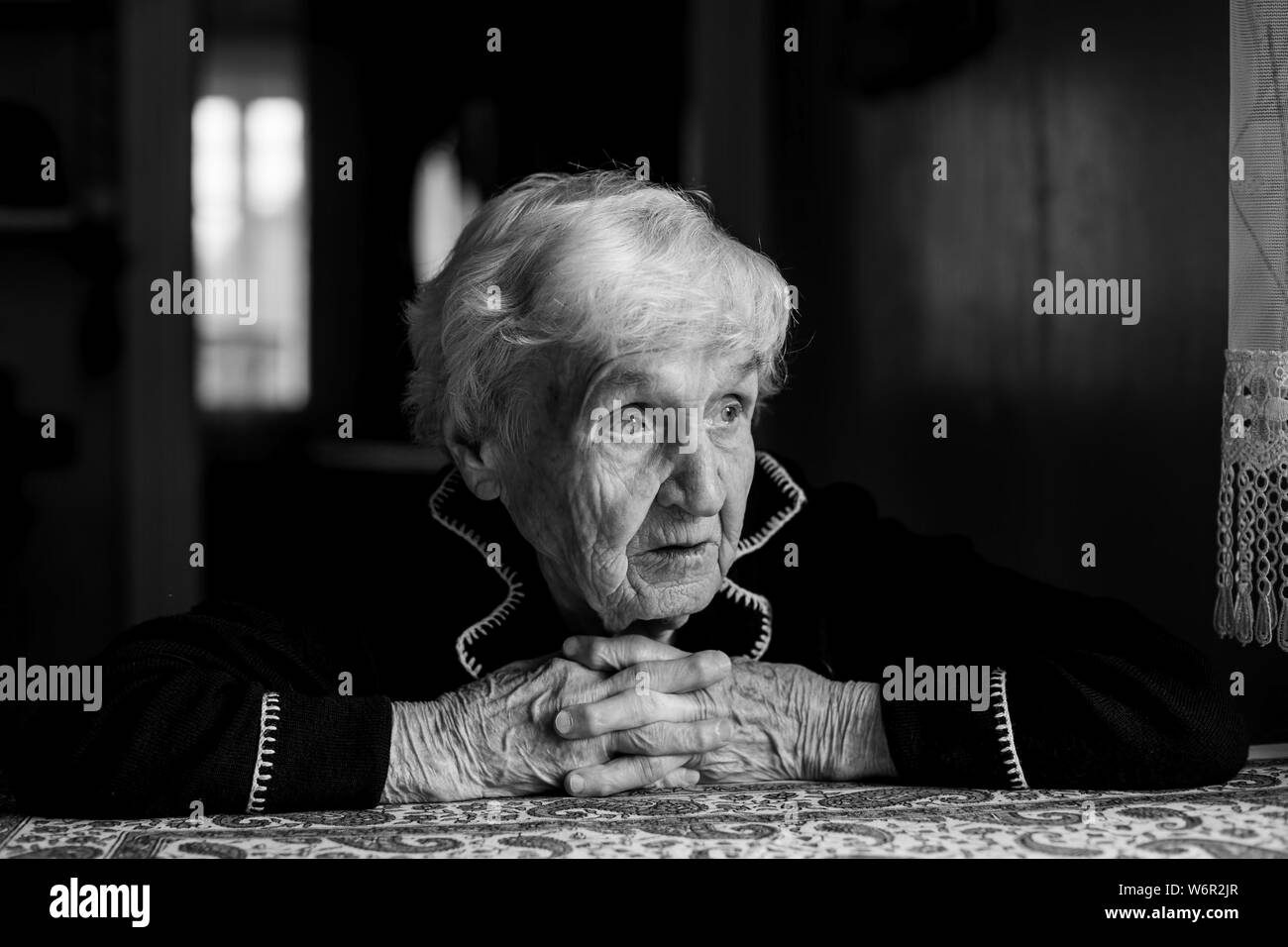 Portrait of a lonely sad old lady. Black and white photo. Stock Photo