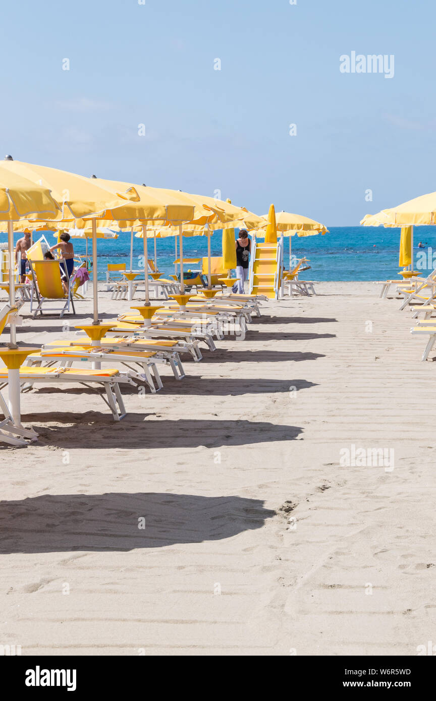 Vertical view of beach umbrellas and tourists enjoying beach facilities at Lido Di Ostia on a sunny summer day.  This beautiful beach is located only Stock Photo
