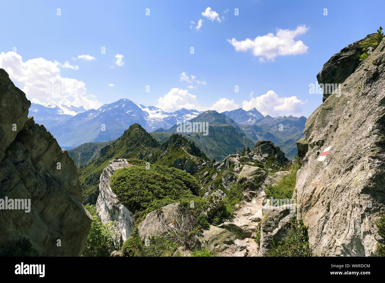 View of the Alpine mountains in Switzerland against a blue sky with white clouds on a bright Sunny day. Stock Photo