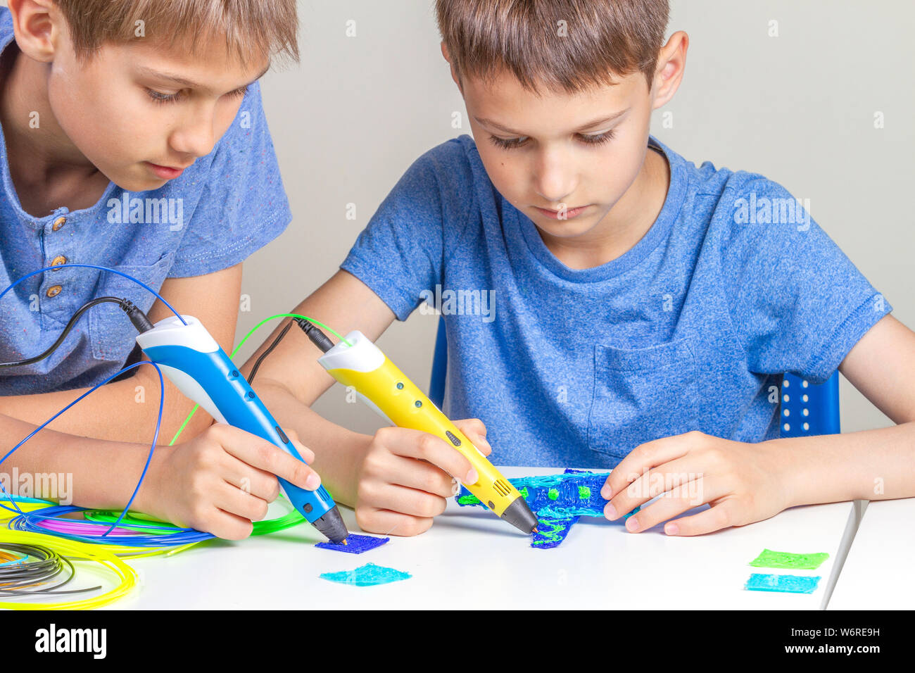 Two boys creating with 3d printing pens Stock Photo - Alamy