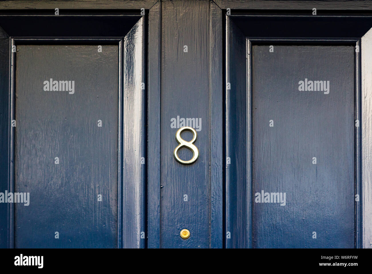 House number 8 on an elegant black wooden front door Stock Photo