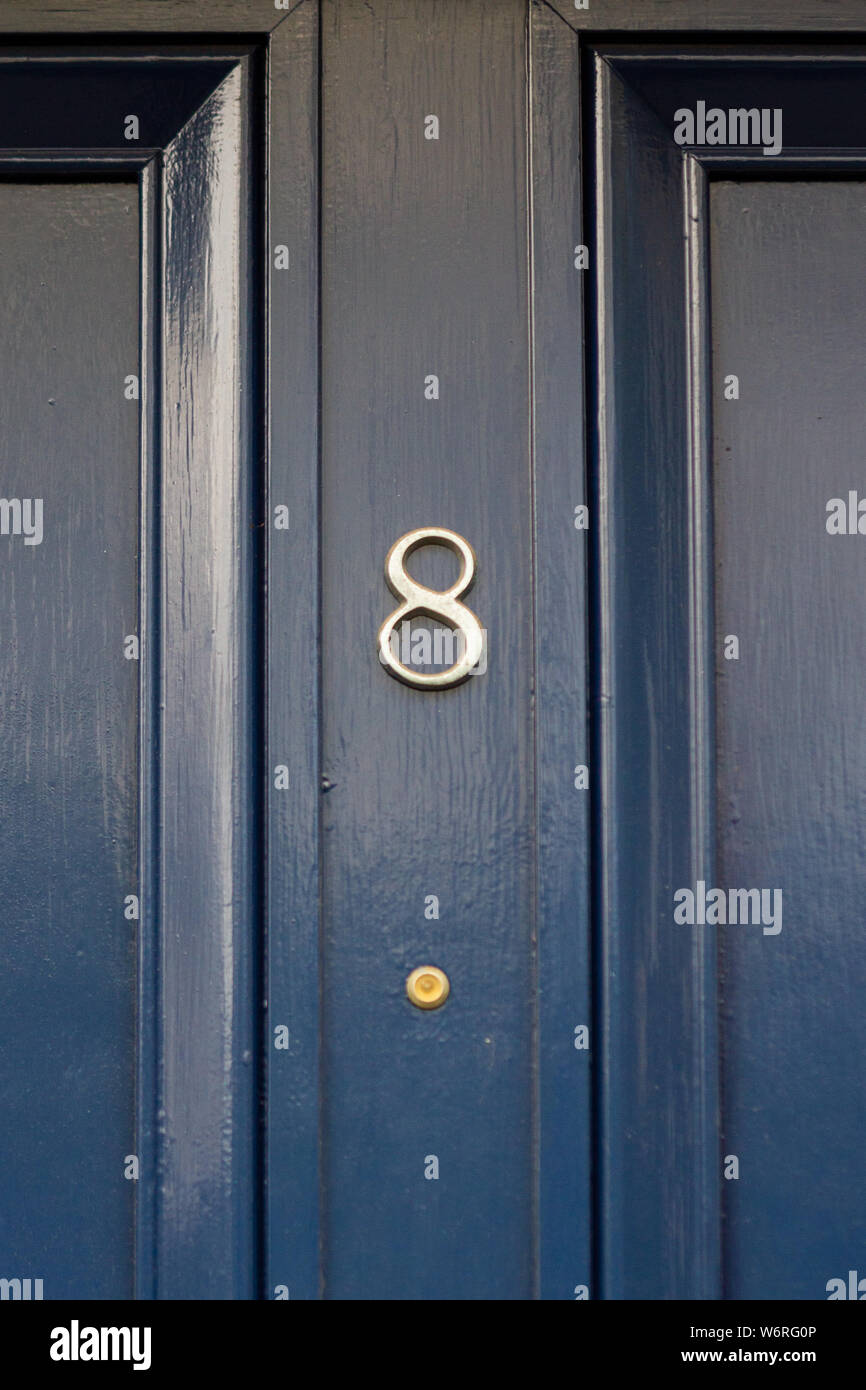 House number 8 on an elegant black wooden front door Stock Photo