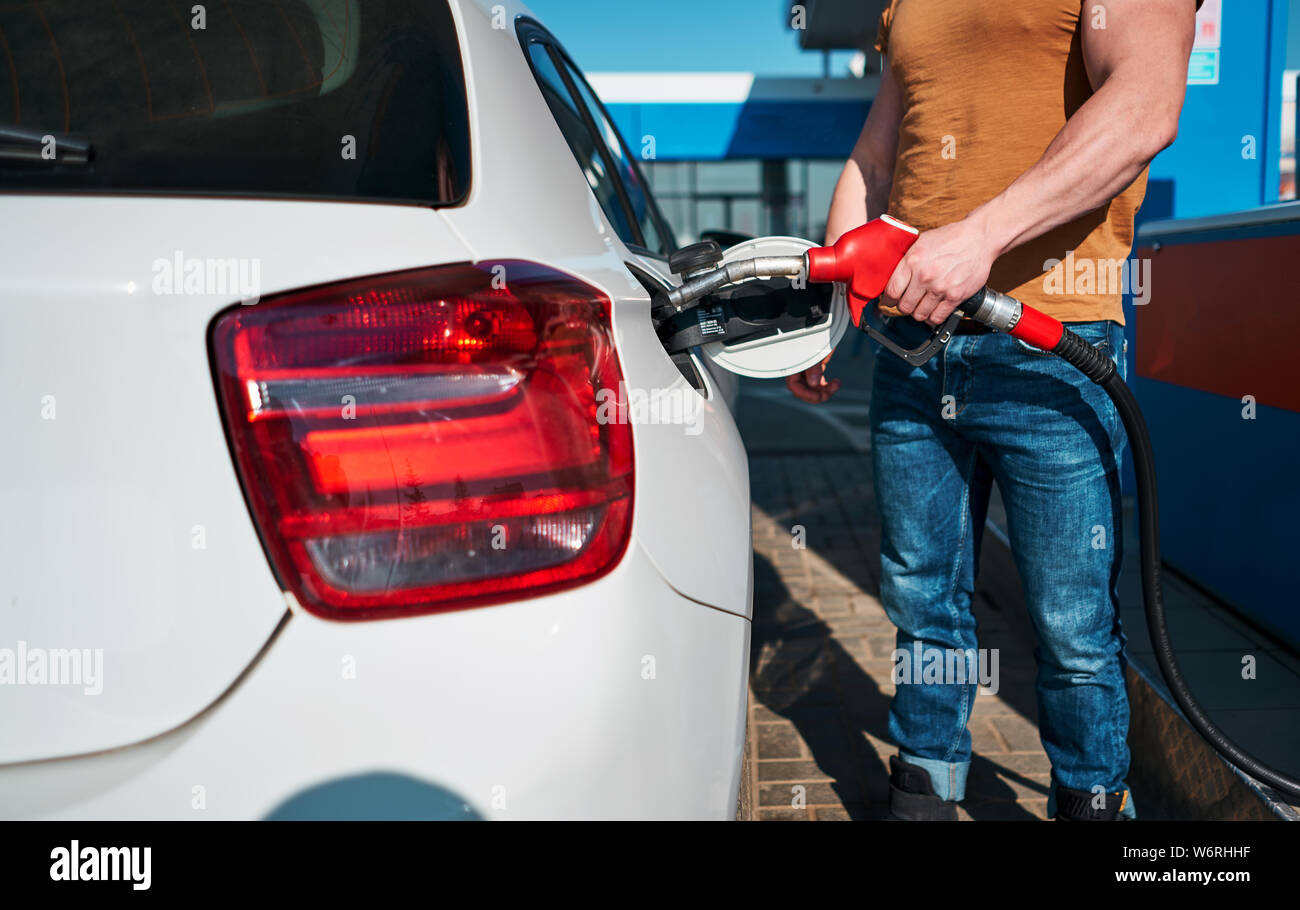 Man fueling his car at a self service petroleum gas station hires