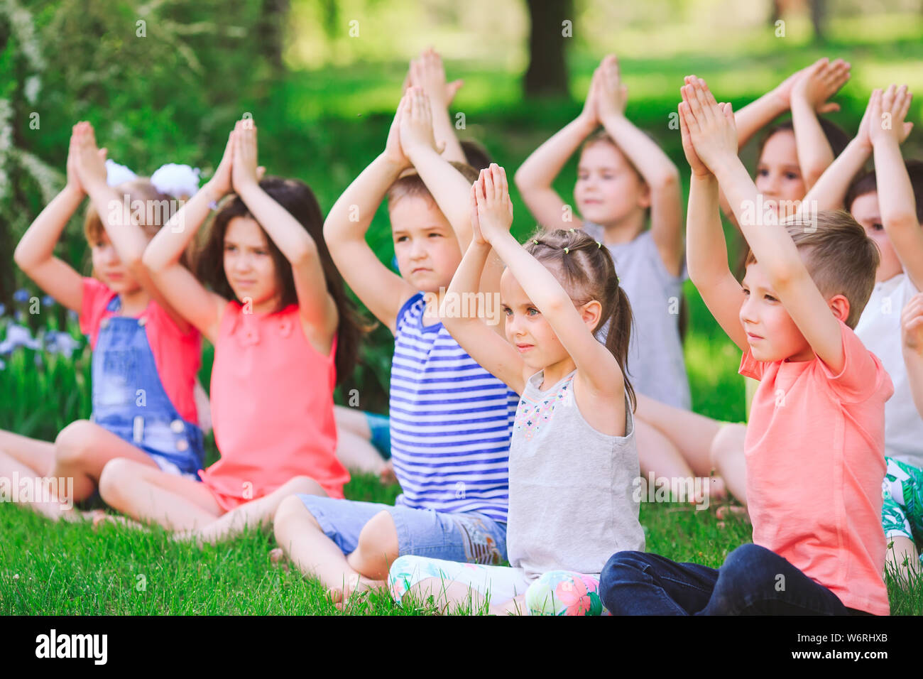 A large group of children engaged in yoga in the Park sitting on the ...