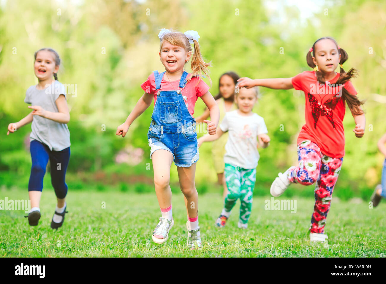 Many different kids, boys and girls running in the park on sunny summer day  in casual clothes Stock Photo - Alamy