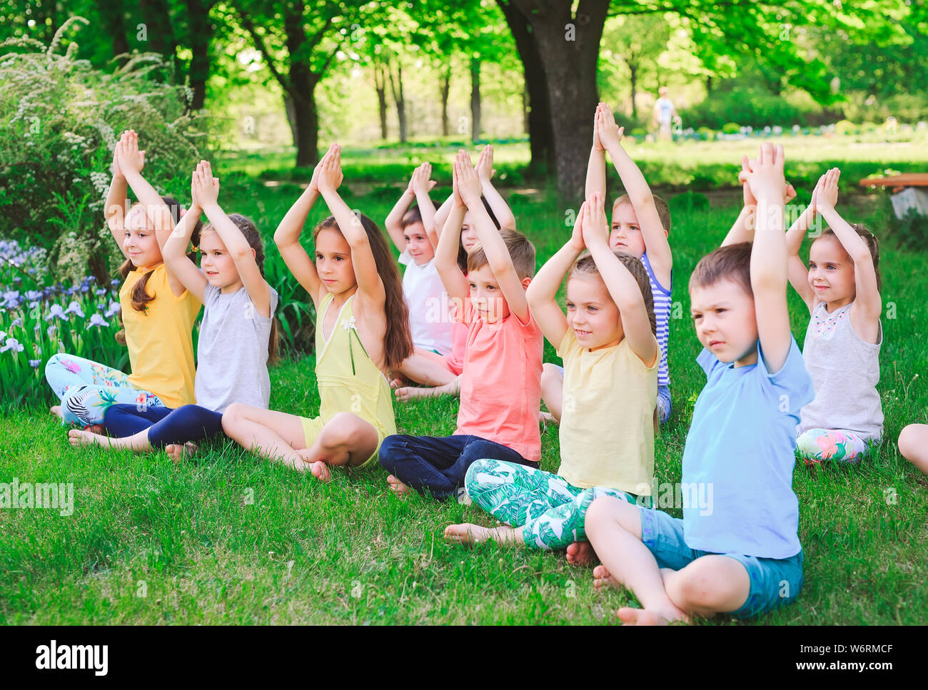 A large group of children engaged in yoga in the Park sitting on the ...