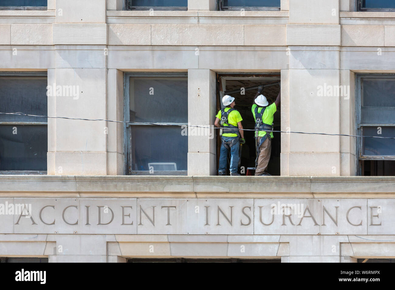 Detroit, Michigan - Two construction workers on a ledge on the third floor of the Standard Accident Insurance Company building. Built in 1920, the str Stock Photo