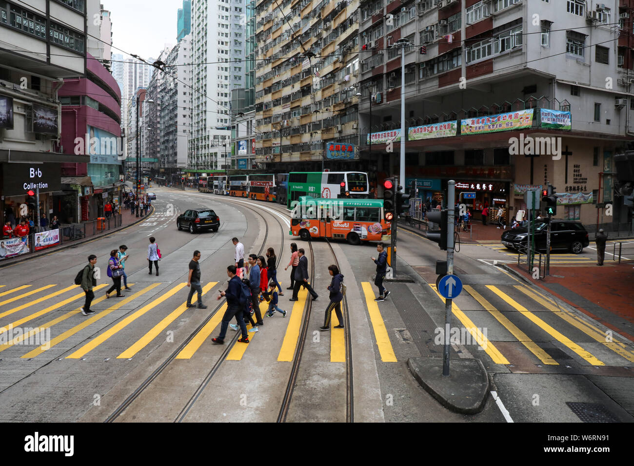 Incidental Hongkongers crossing King's Road in North Point, Hong Kong Stock Photo