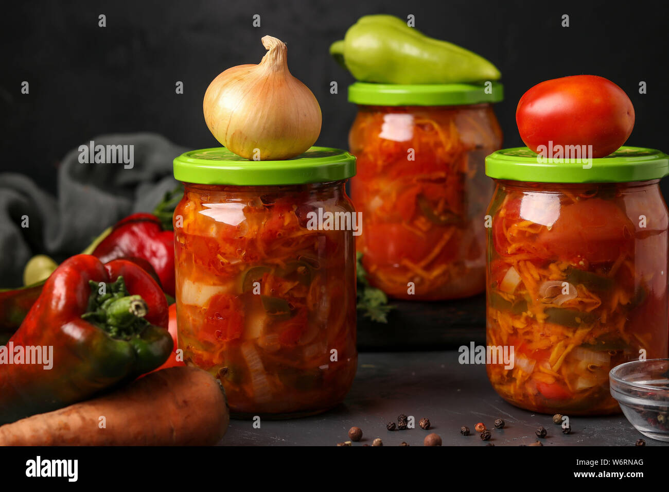 Vegetable salad in jars for the winter of tomatoes, carrots, onions and peppers, horizontal arrangement Stock Photo