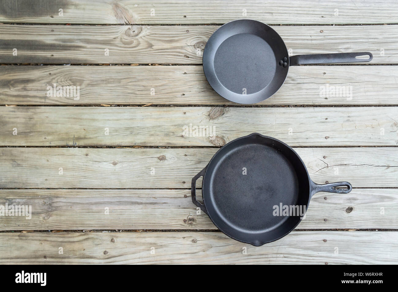 Cast iron vs carbon steel vs teflon pans. Skillet cookware battle comparison for healthier cooking options from stove to oven to campfire. Blank empty Stock Photo