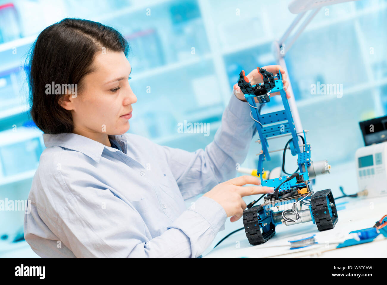 Student in CNC (computer numerical control) and robotics laboratory, experiment with microcontroller and robot CNC module. Stock Photo
