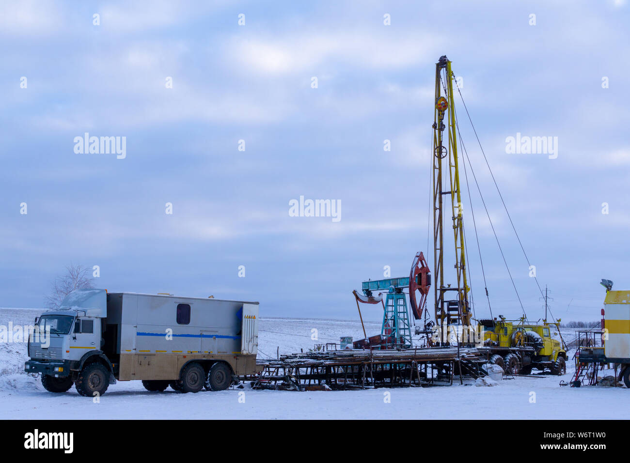 Wireline equipment hanging from top drive ready to be lowered downhole for  logging. An oil well engineer works from the back of specialised van to log  Stock Photo - Alamy