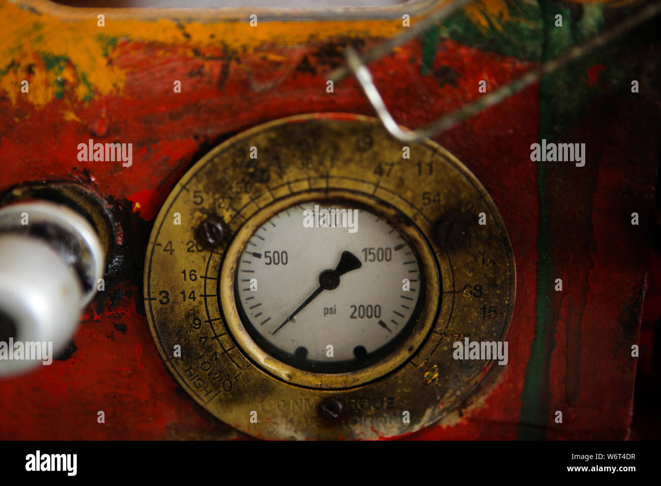 Details of a steampunk like old, dirty, colorful and rusty PSI manometer on an industrial heavy iron machinery Stock Photo