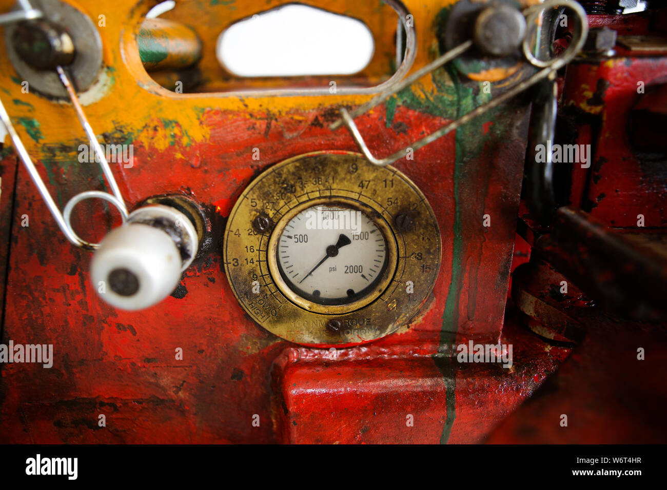 Details of a steampunk like old, dirty, colorful and rusty PSI manometer on an industrial heavy iron machinery Stock Photo