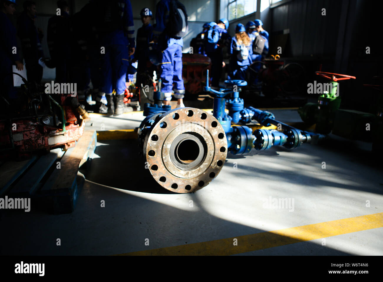 Shallow depth of field image with iron industrial equipment used in the oil and gas drilling industry laid on the ground of a workshop Stock Photo