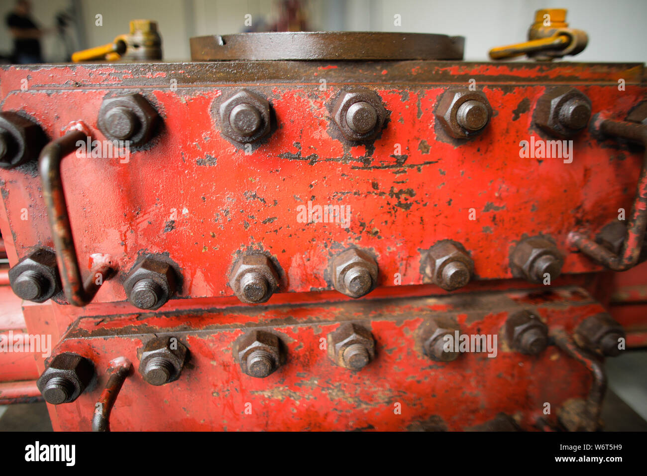 Shallow depth of field image with worn out heavy iron industrial equipment used in the oil and gas drilling industry (rusty bolts, nuts, pipes, levers Stock Photo