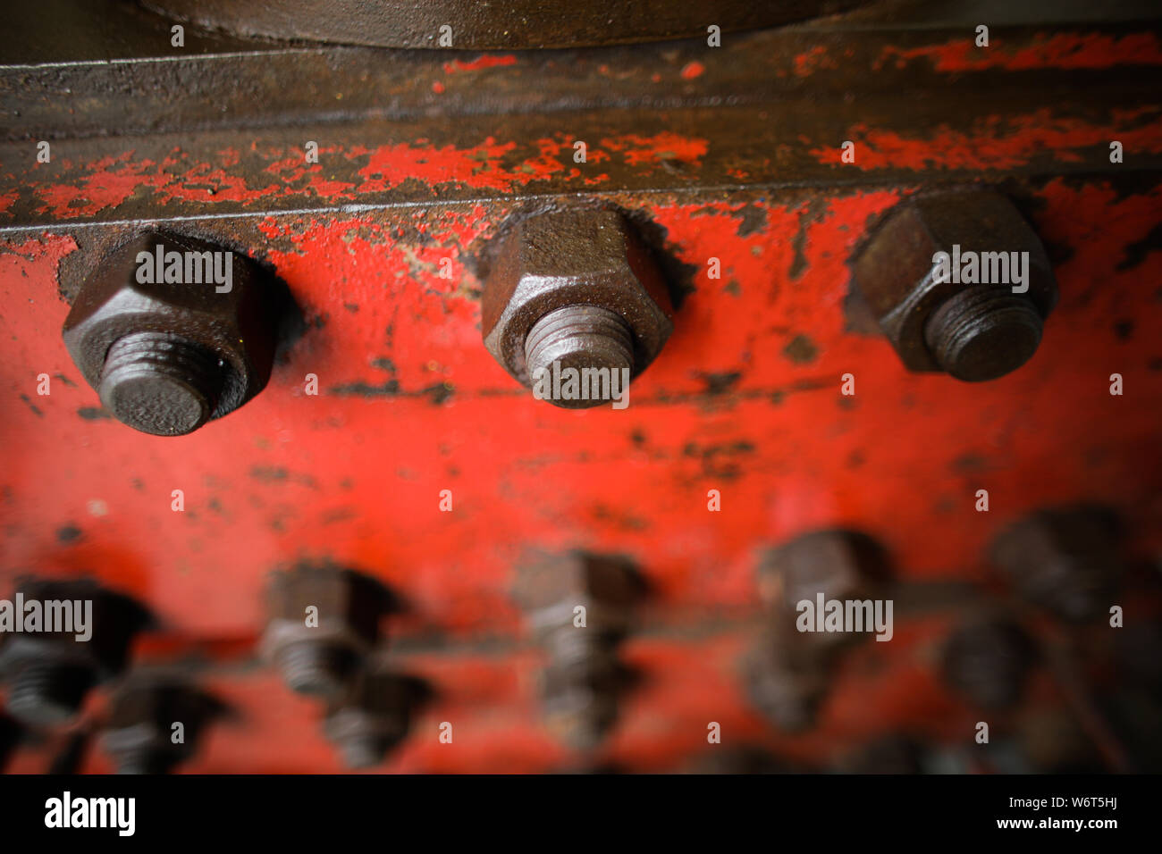 Shallow depth of field image with worn out heavy iron industrial equipment used in the oil and gas drilling industry (rusty bolts, nuts, pipes, levers Stock Photo