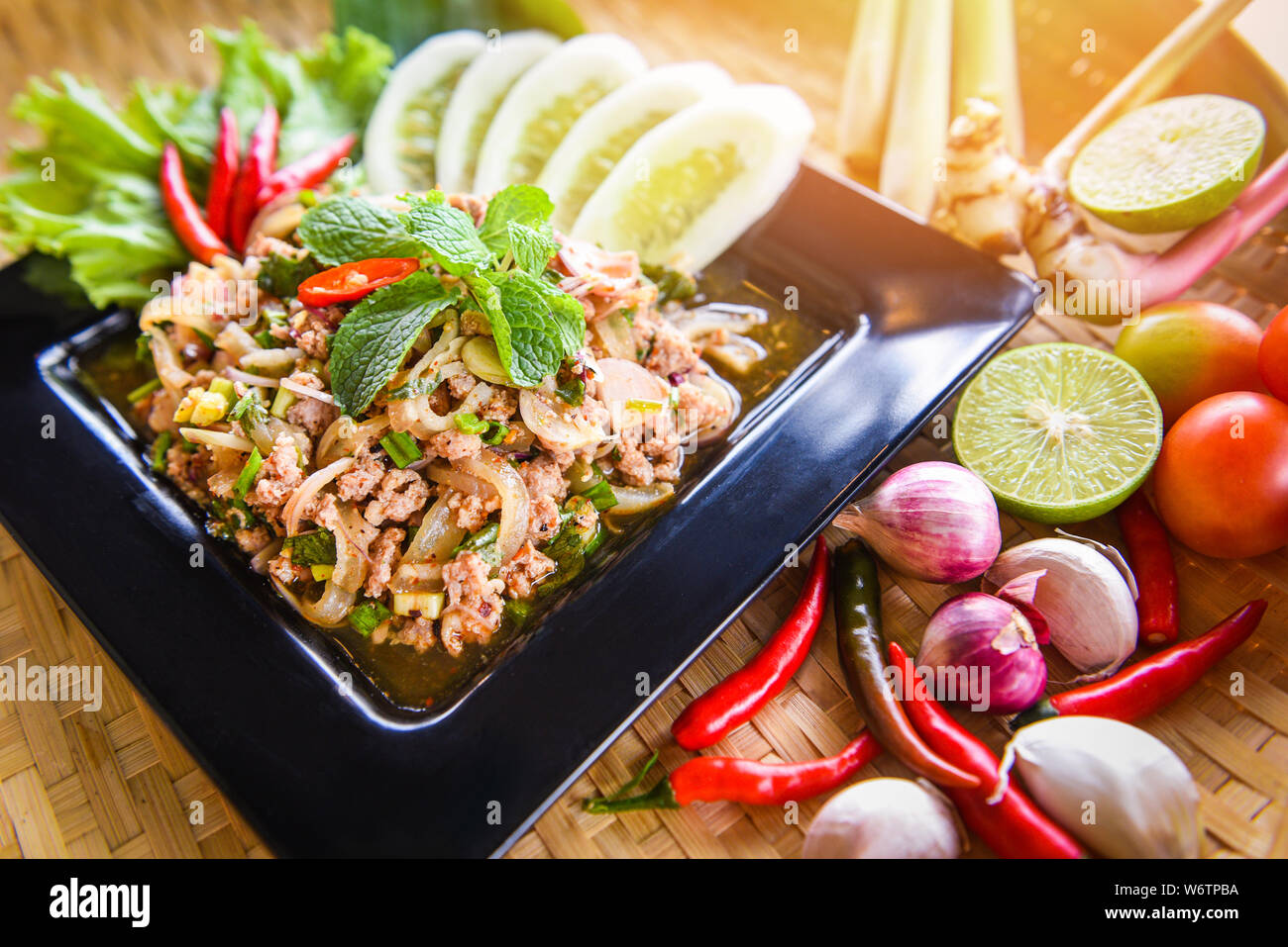 Spicy minced pork salad Thai food served on table with herbs and spices