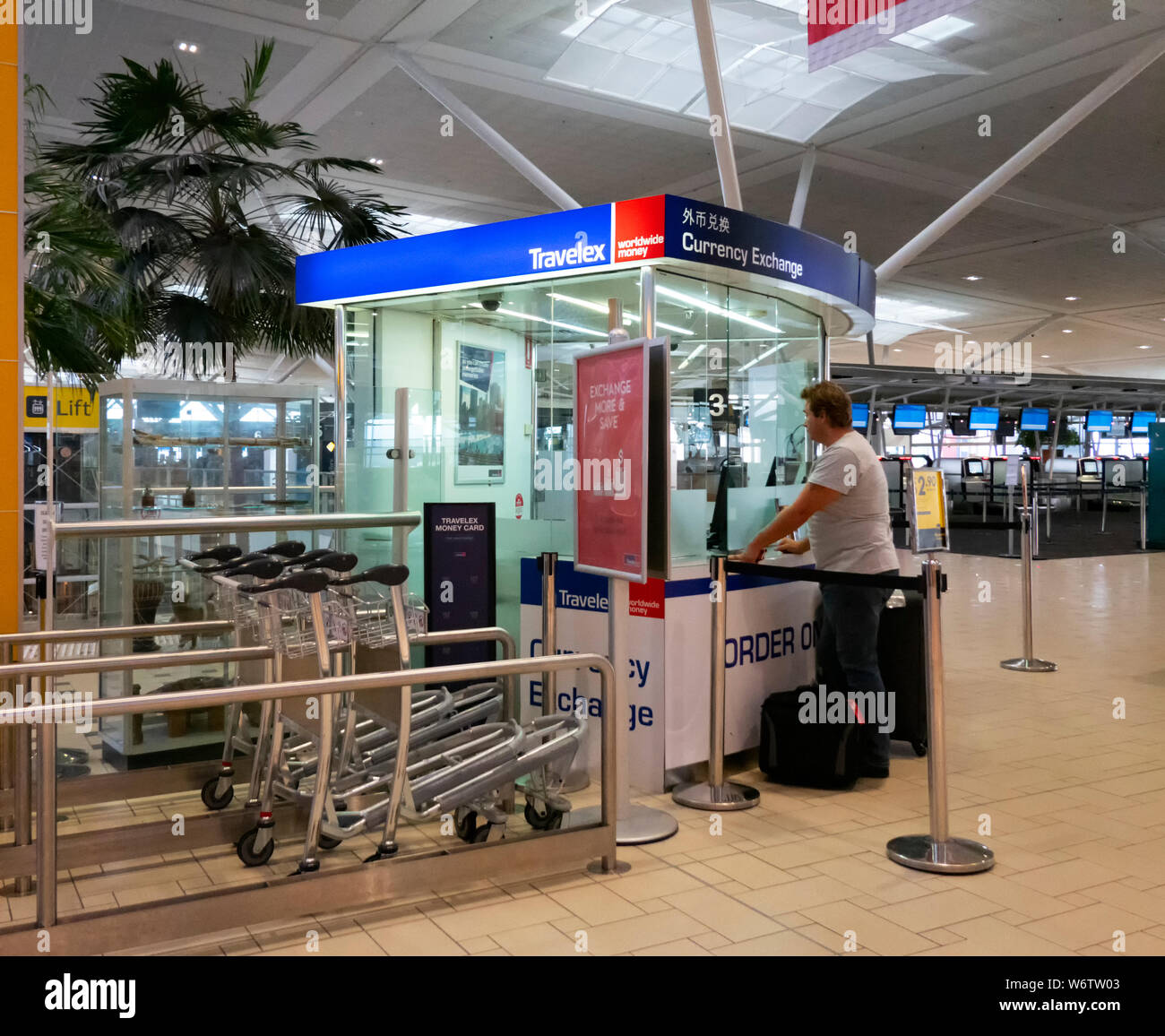 Traveller exchanging currencies at the Travelex desk at Brisbane airport, International Terminal, Queensland, QLD, Australia Stock Photo