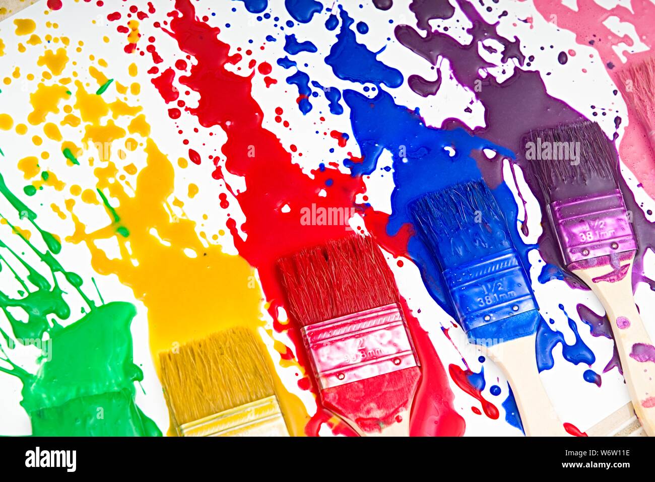 Paintbrushes dripping paint of various colors Stock Photo Alamy