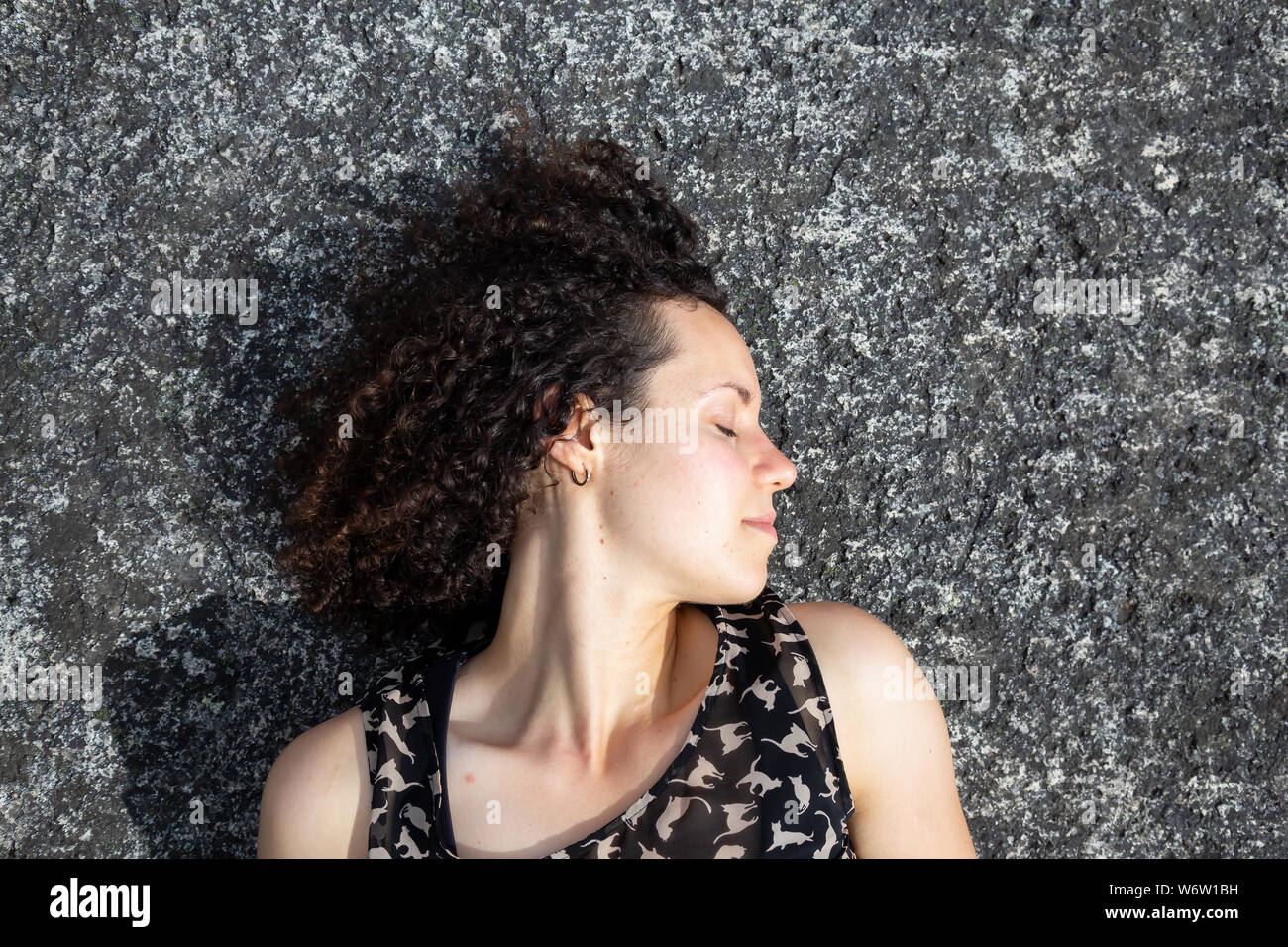 Young Beautiful Caucasian Girl With Curly Hair Is Relaxing On A