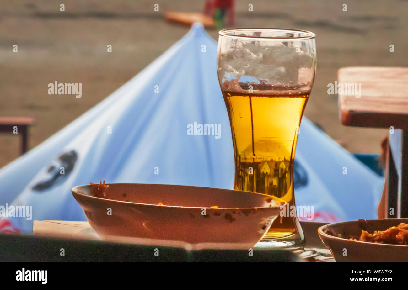 Cold beer on desk and background of summer beach with palm vagator beach Goa India Stock Photo