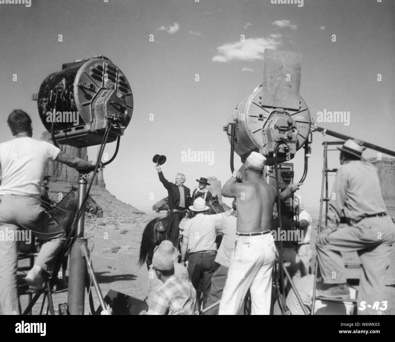 JOHN WAYNE and WARD BOND on location Monument Valley candid filming on set THE SEARCHERS 1956 director John FORD novel Alan Le May C.V. Whitney Pictures / Warner Bros. Stock Photo