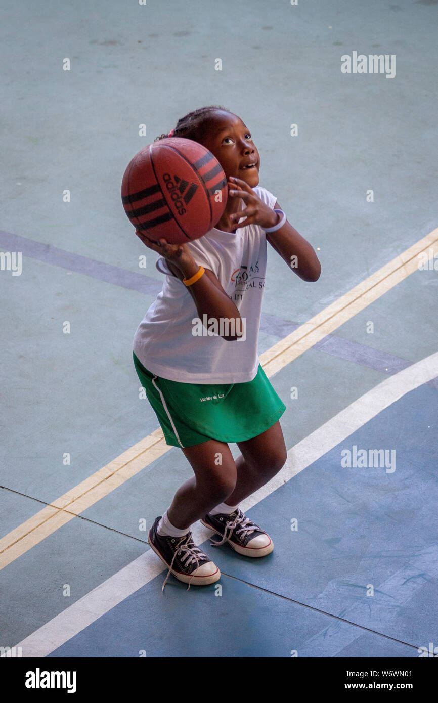 Young girl with basketball in her hands concentrated and ready with knees bent to throw the ball Stock Photo