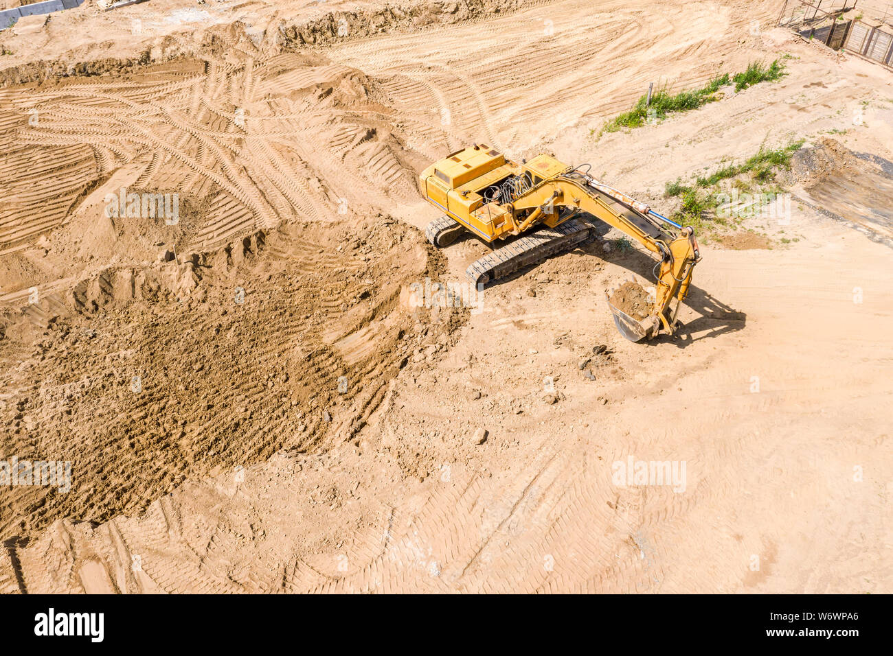 aerial top view of yellow industrial excavator doing ground works at ...