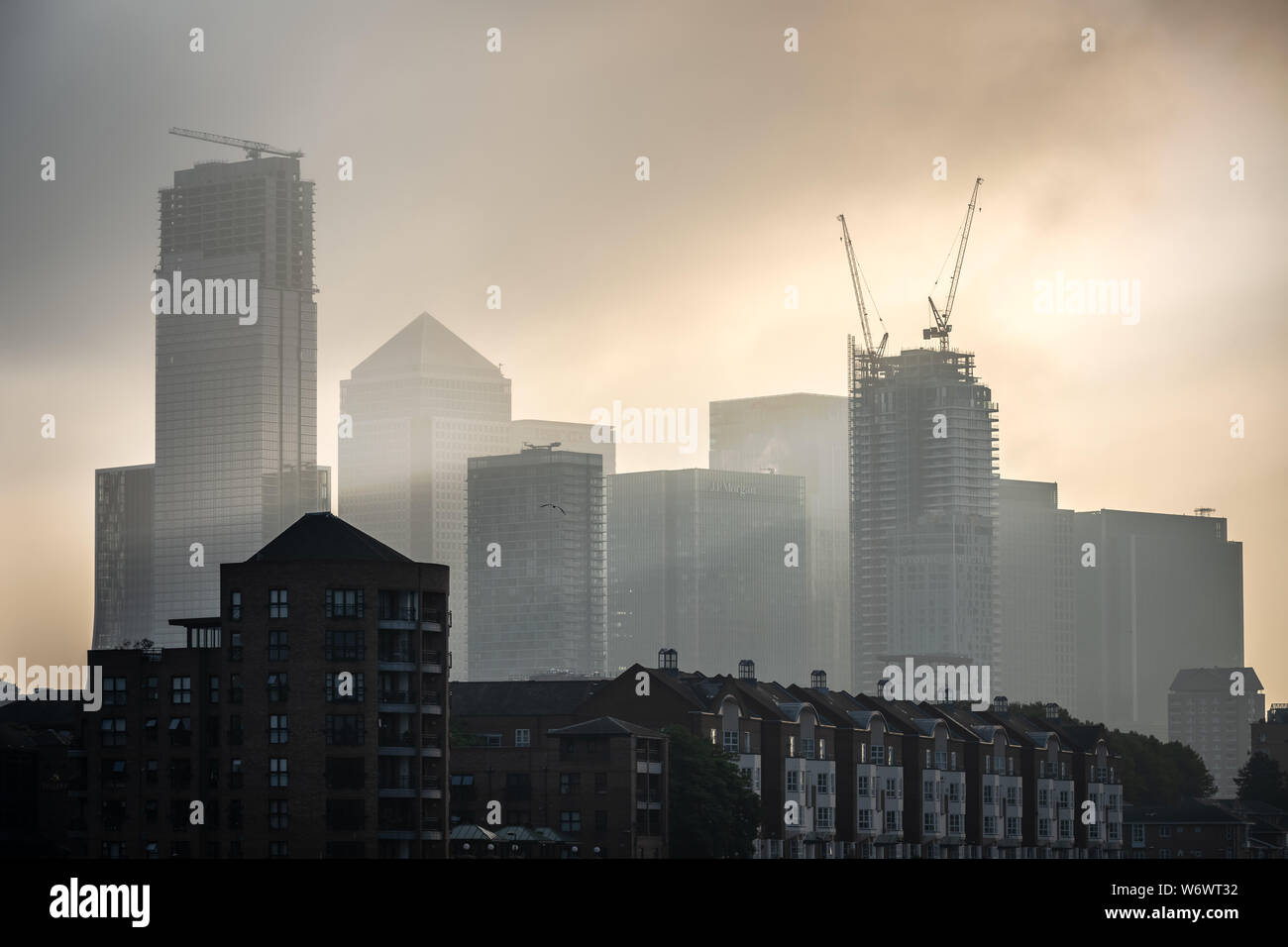 London, UK. 2nd August, 2019. UK Weather: Dramatic morning light breaks over Canary Wharf business park buildings - seen from Greenland Dock, Surrey Quays. Credit: Guy Corbishley/Alamy Live News Stock Photo