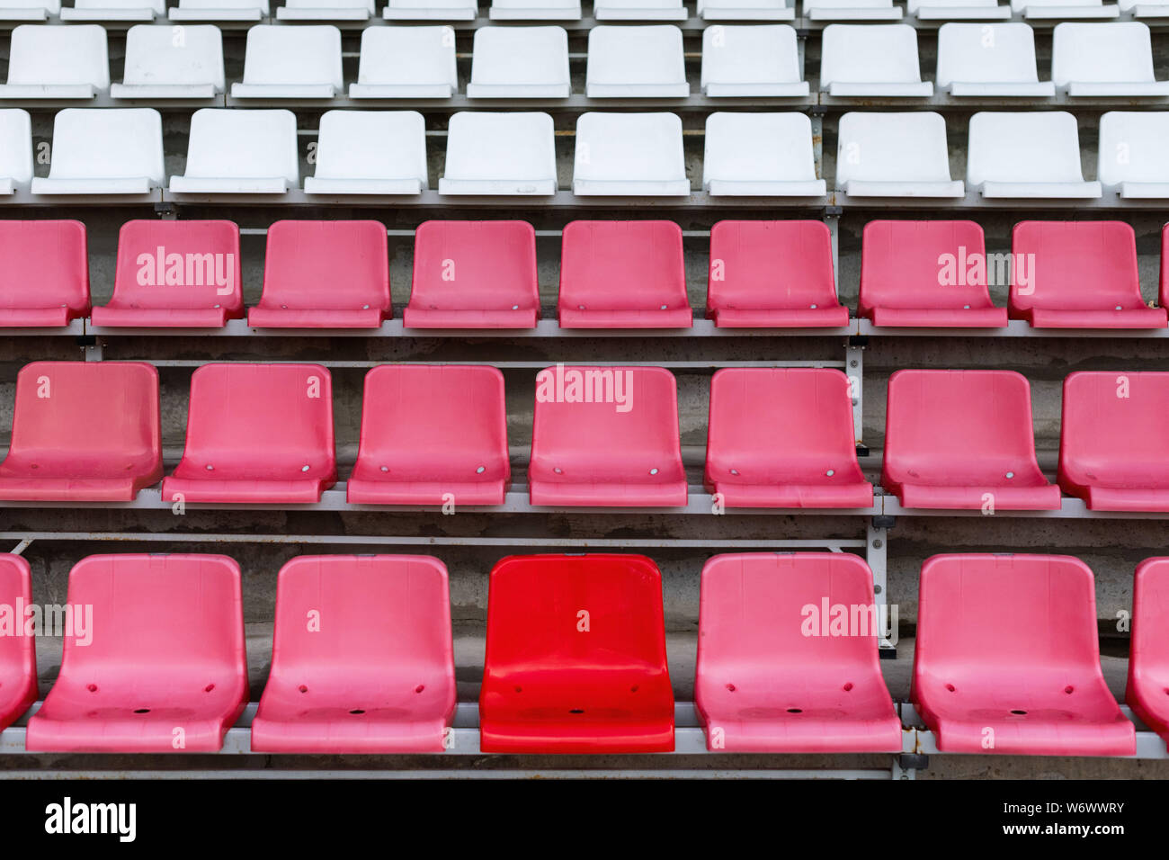 Stadium seats, one seat stands out in red color. Soccer, football or  baseball stadium tribune without fans Stock Photo - Alamy