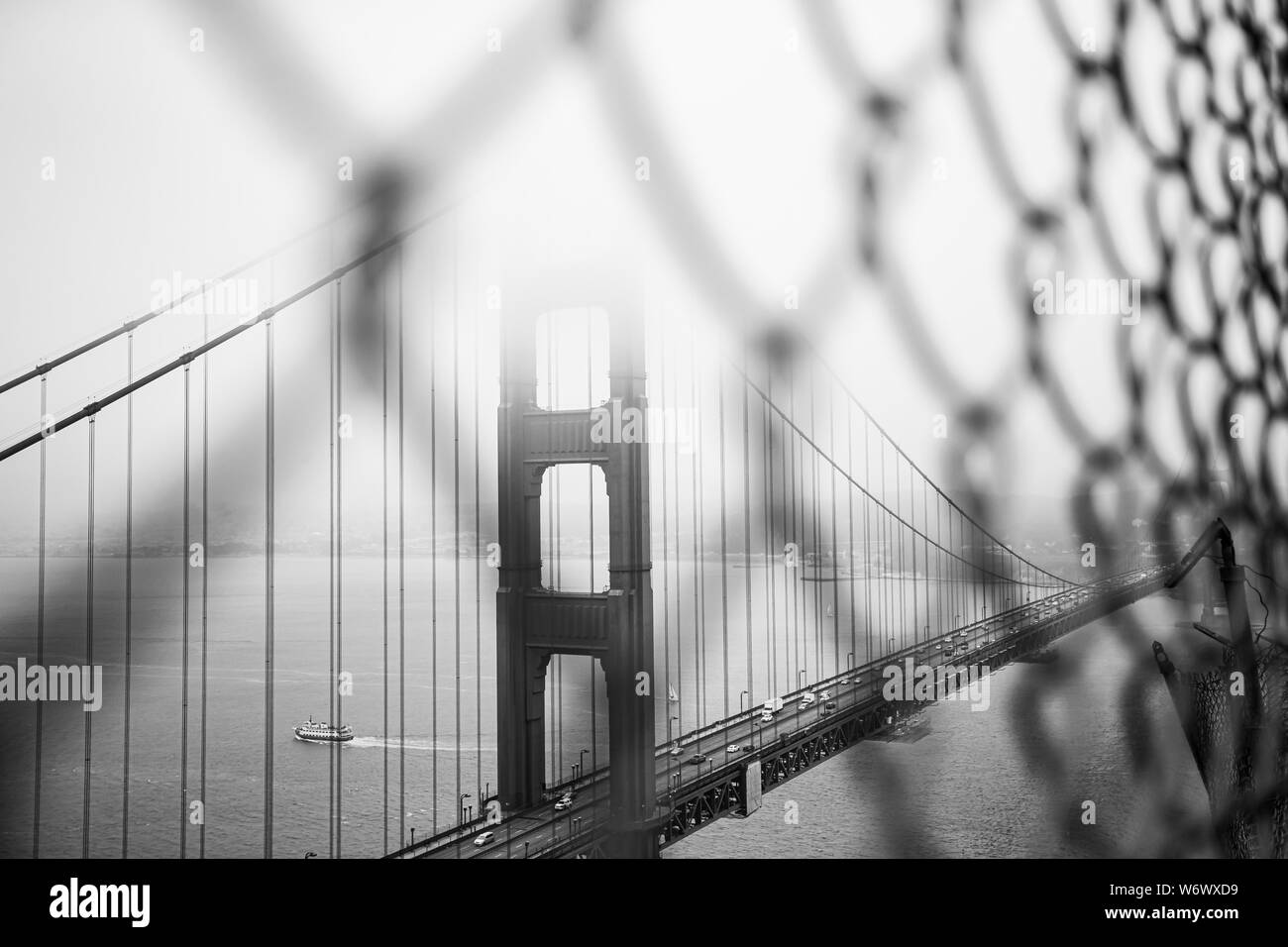 The Golden Gate Bridge, San Francisco, viewed through a wire fence on Marin Headlands in Black and White. Stock Photo